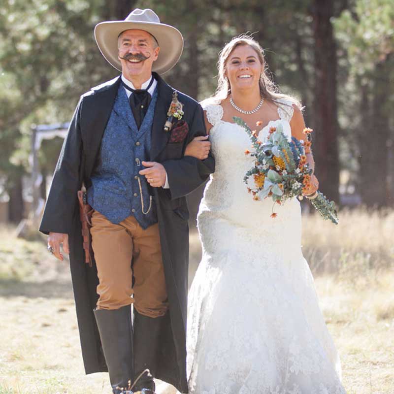 Happy bride with her father wearing vintage western clothing